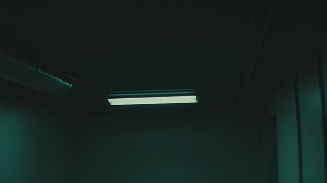 Minimalist interior of a shadowy hallway with a single fluorescent light creating an eerie atmosphere, emphasizing concepts of eeriness, solitude, and uncertainty in an an empty space