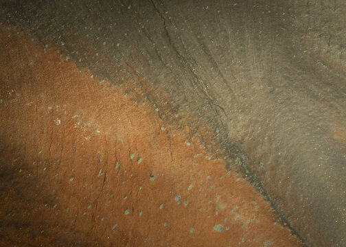 Aerial view of the stark, contrasting landscape where rusty earth meets ashen ground, textured with subtle patterns, creating a surreal vista, Myvatn, Thingeyjarsveit, Iceland.