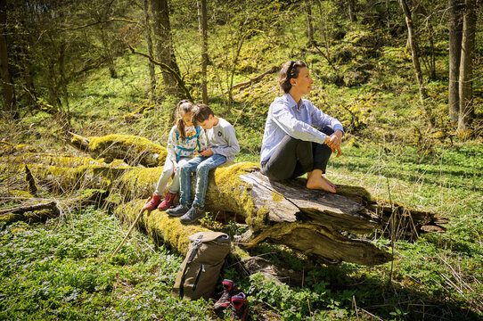 Woman exploring forest while children are addicted to smart phone at Swabian Jura