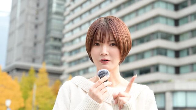 カメラ目線でピンマイクを使って話す日本人女性