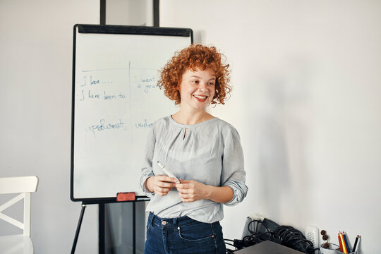 Smiling businesswoman leading a presentation at flip chart in conference room