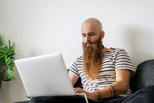 Portrait of hipster using laptop at home