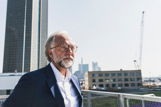Serious mature businessman in the city looking around