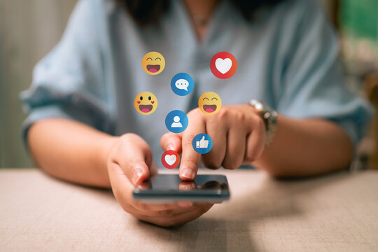 A woman is playing on her mobile phone. The concept of social media includes chatting with friends online and sending reaction icons through the application.