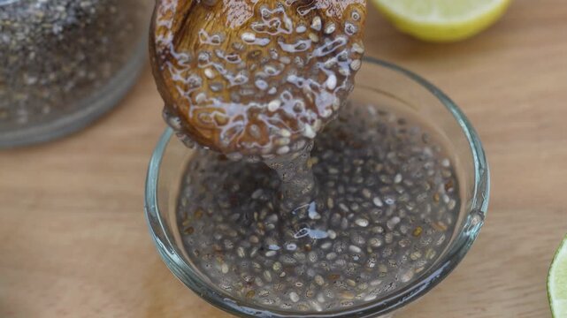 Easy to digest chia seed gel rich in calcium and dietary fiber in a glass bowl on rustic wooden background. Selective focus on chia seeds.