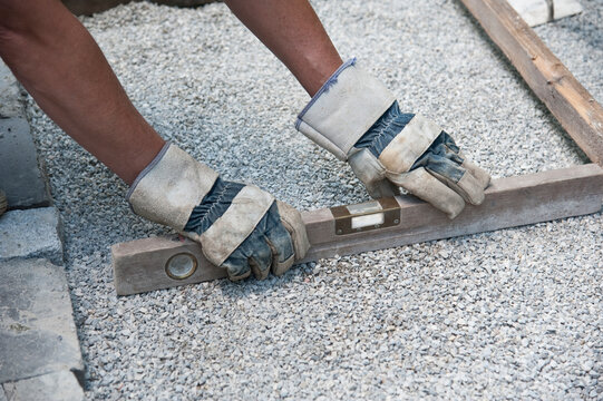 Man paving a way, checking with water level