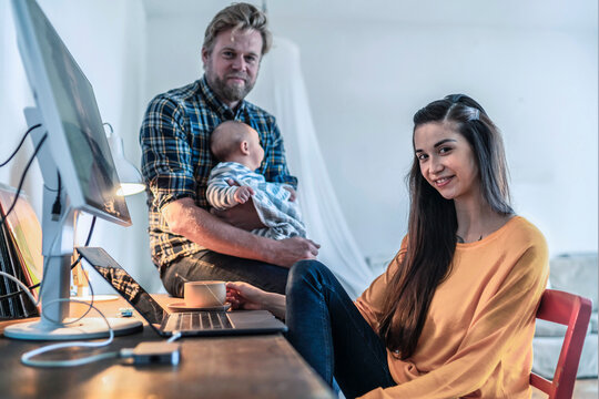 Portrait of young woman with her family in home office