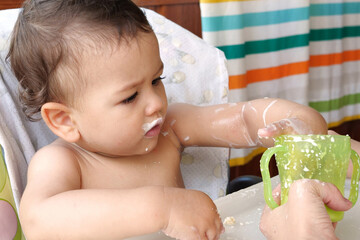 children eating healthy food at home or kindergarten. Happy toddler boy drinking white kefir