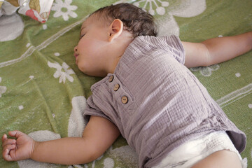 close-up portrait of a beautiful sleeping baby on bed. New family and baby protection from mom concept