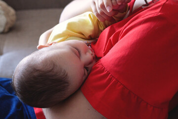 mother breastfeeding baby at home. motherhood and maternity care concept. Cheerful mom enjoy breastfeeding