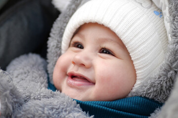 Happy little baby boy making outdoors in winter. Cute toddler in winter cloth. Child having fun on cold day. Winter walk outdoors