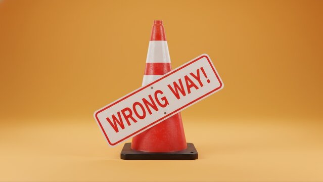 Red and white traffic cone with a warning message sign displaying the words wrong way against an orange background