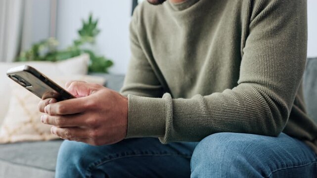Hands, phone and man texting and relax, rest on a sofa at home on the weekend. Social media, streaming and zoom in of hand typing, internet search for online entertainment or fun dating social app