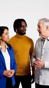 Diverse Group of Three People Standing Together, Engaging in Conversation