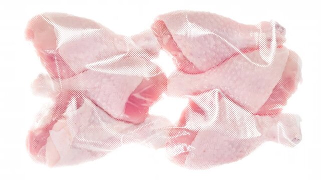 Packing and Freezing Chicken Feet. Chicken legs are vacuum packed and quickly cooled with an ice jet, creating a white steam effect on a white background