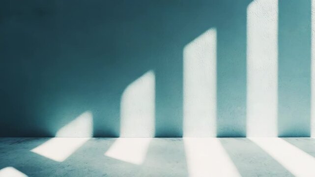 Empty room featuring strong natural window light casting abstract, parallel stripes and geometric shadows onto a textured wall and concrete floor, creating a peaceful, minimalist interior