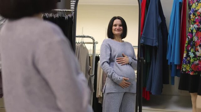 A pregnant woman in a clothing store. Trying on clothes. Clothing store. Slow motion video.High quality 4k footage