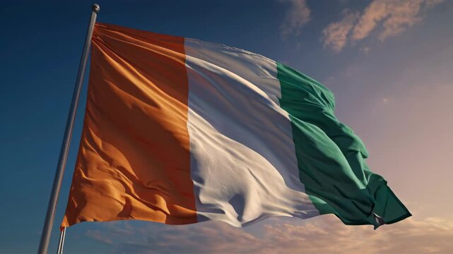 Ivory coast flag waving proudly on a flagpole, illuminated by a warm sunset, symbolizing national pride, independence, patriotism, and sovereignty for west african nation cote d'ivoire