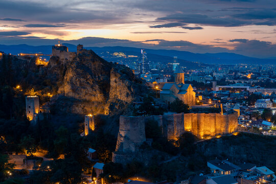 Illuminated Narikala Fortress And Church At Dusk In Tbilisi Georgia