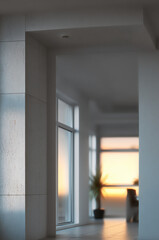 Modern interior space with large window, soft sunlight, white walls, and minimal decor, creating calm and inviting atmosphere