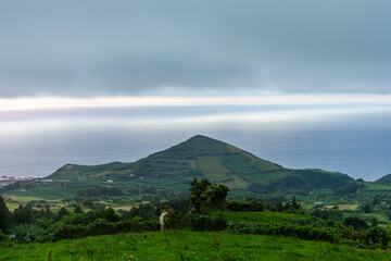 Obraz premium San Miguel, Azores. Green landscape with mountains and scenic views. Atlantic coastline in the distance. Rural setting with natural scenery.