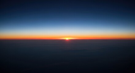 A vibrant sunrise seen from above, with layers of color in the sky