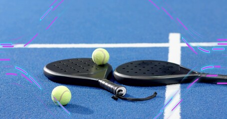 Showing black padel paddles resting on blue court near white lines with three balls and strap