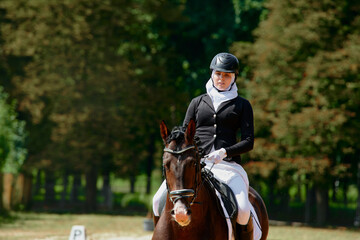 Equestrian Sport, Woman Riding Horse in Dressage Competition, Outdoor Scene with Natural Green Background, Horseback Riding, Dressage Training, Equestrian Lifestyle
