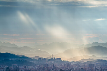 Stunning view from Dadao Mountain Shulin Taiwan. Dramatic light rays penetrate rain clouds over...