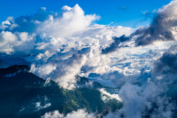 Fototapeta premium Aerial view of Hehuanshan, Renai, Nantou, Taiwan. Early autumn sun lights a winding mountain road above a sea of clouds and green slopes.