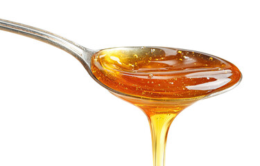 Honey pouring from a spoon.  Golden liquid honey flows from a metal spoon against a black background