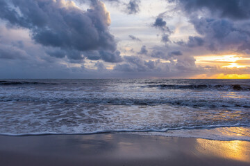 Fototapeta premium Sunset on Beach with Dark Clouds and Yellow Light
