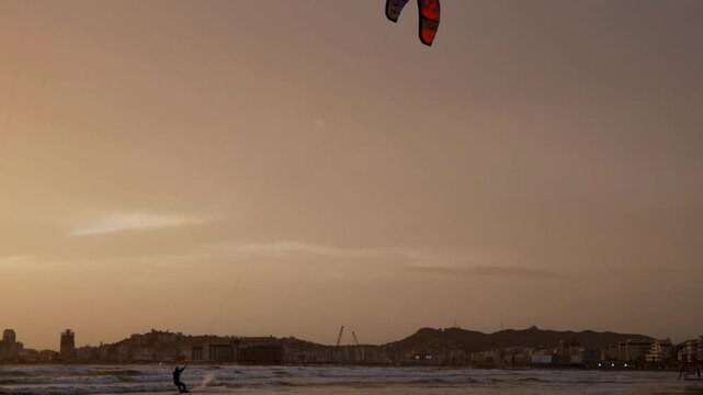 Kitesurfer in motion at sunset, extreme sport on the tropical beach.