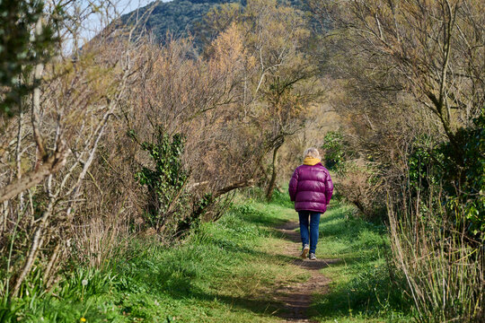 Woman walking on nature trail in early spring