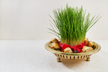 Nowruz sabzeh grass and baklava on haft-sin display