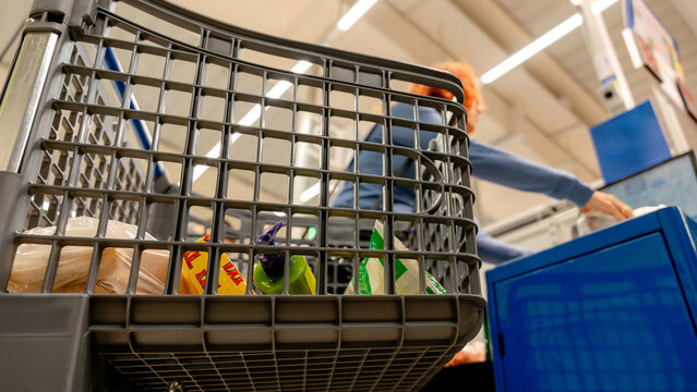 Woman shopping in supermarket with cart close-up