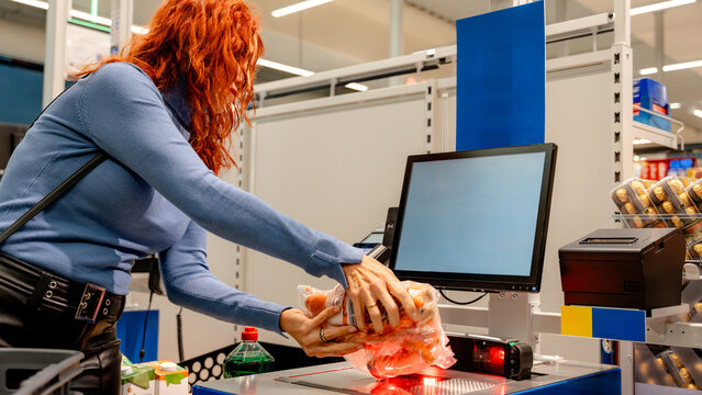 Woman shopping at a self-checkout in a supermarket