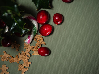 Christmas gingerbread men minature cookies wiith candy cane green background