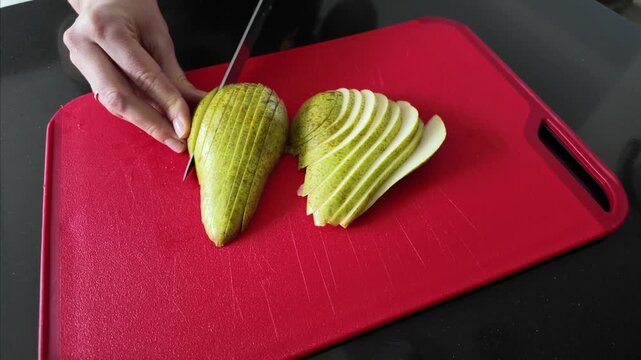 Two pear halves meticulously sliced into uniform pieces, arranged and ready for baking into a delicious dessert or side dish. Ideal for baking blogs, recipe tutorials