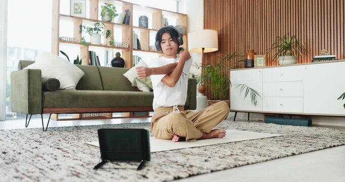 Man, stretching and headphones with tablet for yoga course, online tutorial or exercise in home. Asian, male person or streaming with technology or warm up for virtual guide, health or wellness tips