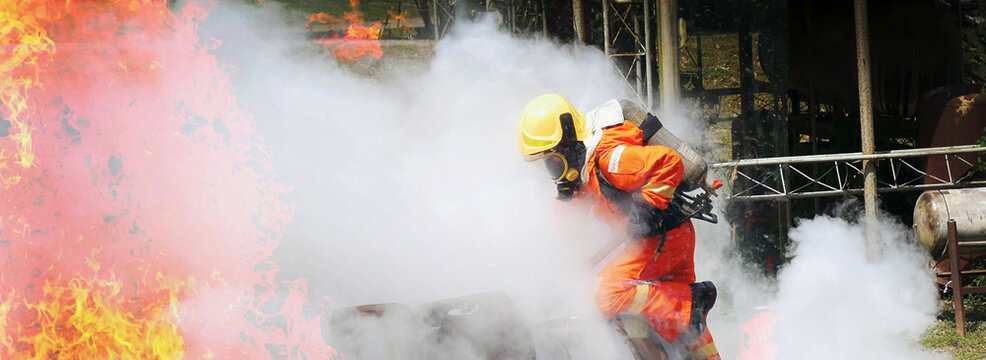 Banner Firefighter Rescue team training in fire fighting. Panorama Teamwork Firefighter fighting flame using fire hose chemical water foam spray. Fireman teams safety uniform hard hat with copy space