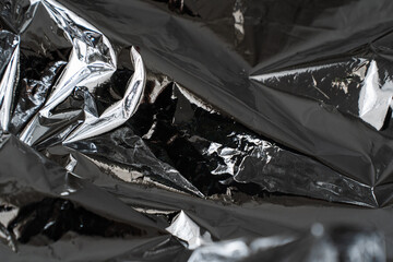 Deep dark crumpled metallic foil texture with dramatic shadows