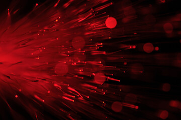 Close up red optical fibers with soft bokeh effect on dark background.