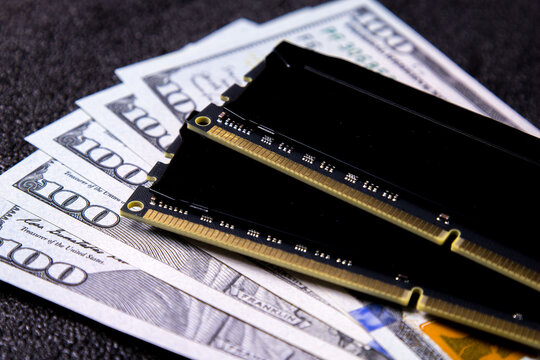 Money placed next to computer memory sticks on a dark surface, rising prices for PC memory