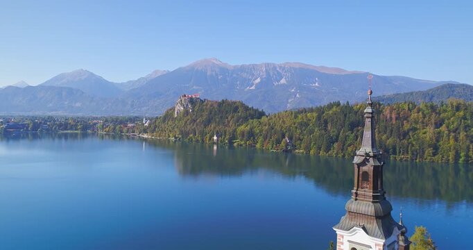 Aerial view of island in alpine lake with mountains in background