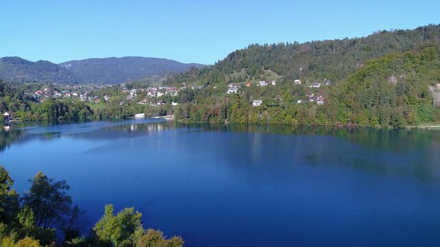 Aerial view of lake and small town surrounded by green hills
