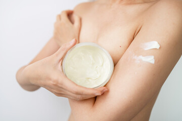 Fototapeta premium Asian woman applying body cream on arm, beauty skin care concept.