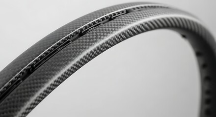 Naklejka premium Close-up of a modern carbon fiber bicycle wheel rim with intricate weave pattern.