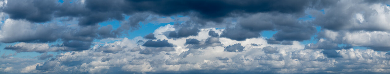 Panoramic blue sky with layered white clouds