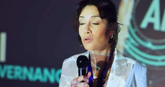 Stage, woman and business speaker in workshop for ai data governance, ethical guidelines and training conference. Professional, person and discussion with mic in international summit for compliance